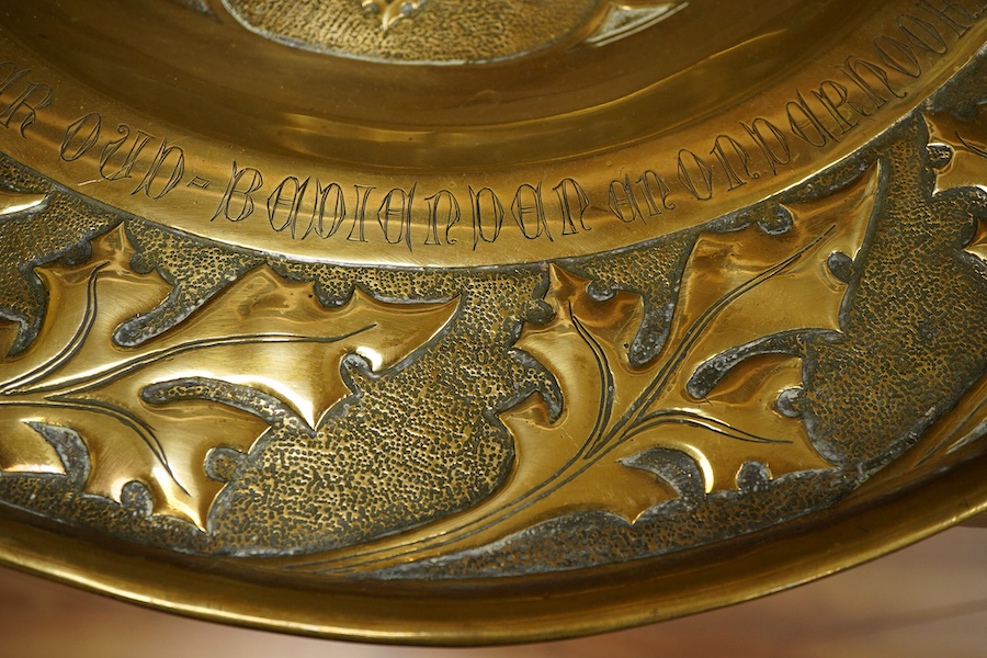 An embossed brass arts and crafts alms charger with inscriptions, 51cm in diameter